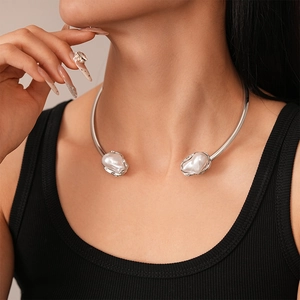 Close-up of silver metal choker featuring irregular faux pearls on a female neck