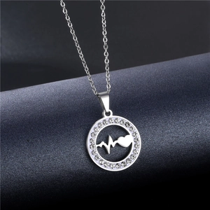 Detail shot of a silver steel necklace with a crystal-encrusted heartbeat pendant