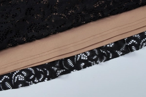 Détail de la dentelle noire sur doublure beige avec une finition délicate de l'ourlet