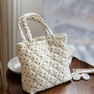 Sac fourre-tout en velours côtelé matelassé avec motifs cœurs sur table en bois
