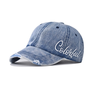 Detail of light blue washed denim baseball cap with Colorful embroidery and distressed brim