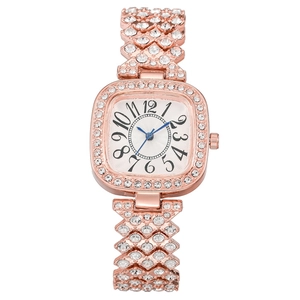 Montre carrée en or rose avec aiguilles bleues et bracelet cristal sur blanc