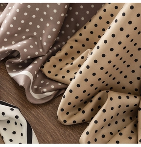 Detailed view of silk scarves with polka dot patterns in beige, brown and white colors
