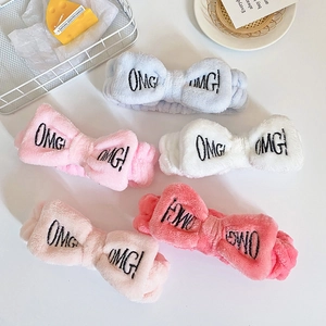 Flat lay of five colorful plush OMG bow headbands in soft coral fleece for face washing