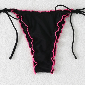 Detail of black bikini bottom with pink ruffles and adjustable side-ties on white texture