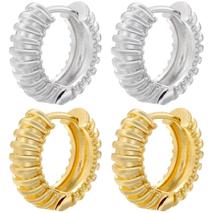 Detail of gold and silver U-shaped hoop earrings with horizontal ribbed texture
