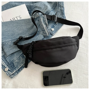 Detail of black nylon chest bag with woven zipper puller and adjustable plastic buckle