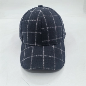 Detailed view of dark blue plaid baseball cap with thick wool-like fabric and white grid