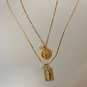 Detailed view of religious Virgin Mary pendant and vintage coin necklace with pearls