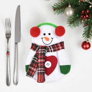 Christmas snowman cutlery holder set with knife and fork on festive decorated table