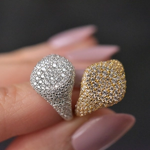 Macro shot of 925 silver and 18K gold rings with pave-set shimmering zircon stones