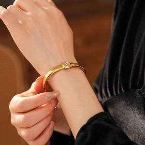 Vue détaillée d'un bracelet en titane doré avec zircons carrés micro-pavés sur un poignet
