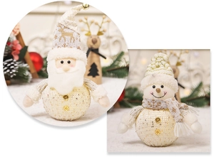 Detailopname van gebreide kerstman- en sneeuwpop-poppen met gouden pailletten decor