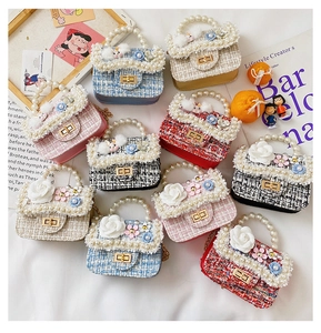 Close-up of assorted mini tweed handbags with pearl handles and cute rabbit charms