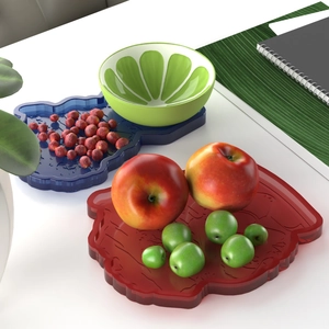Detailed view of handmade resin trays in hand shapes and a lime-shaped ceramic bowl