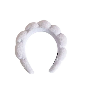 Detail showing plush lavender sponge headband with wave design for skincare and makeup