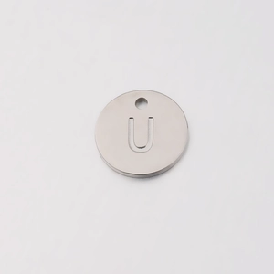 Macro shot of silver mirror polished stainless steel charm with engraved letter U