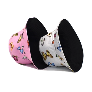Detail of butterfly print bucket hats in pink and white with black lining for summer