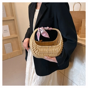 Macro detail of natural rattan handbag with a decorative silk scarf on the handle