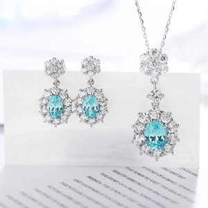 Elegant silver set with oval light blue Paraiba gems and white zircon petals jewelry set