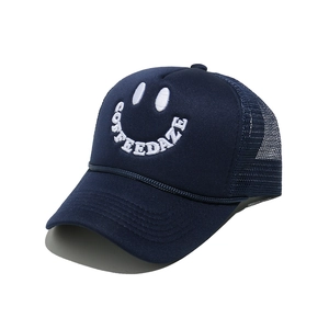 Close-up of navy trucker hat with white Coffee Daze smiley embroidery and mesh back