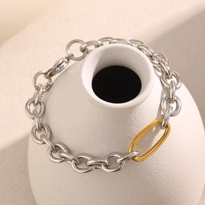 Polished silver and 18K gold-plated chunky chain bracelet shown on a ceramic vase