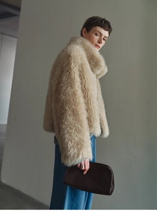 Detailed close-up showing thick faux fox fur texture on a beige cashmere vest with stand collar