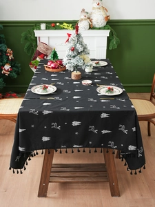 Close-up of black linen Christmas tablecloth with white reindeer embroidery and fringe