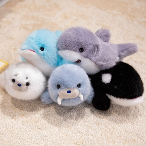 Lot de peluches animaux marins avec dauphin et baleine sur un tapis blanc doux
