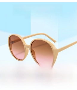 Detail of round oversized sunglasses with beige frames and brown gradient lenses