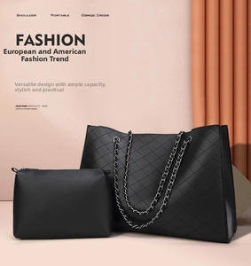 Detail of black pebbled leather tote bag with diamond quilting and silver chain strap