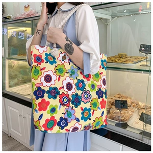 Detail of floral printed canvas tote bag with thick rope handle on shoulder