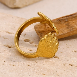 Macro shot of 18K gold plated starfish and shell adjustable ring on stone base