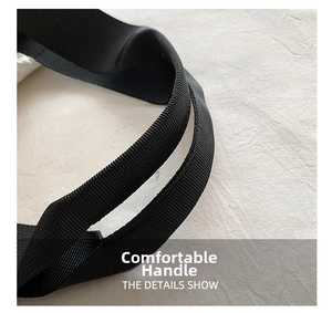 Detailed close-up of the comfortable black woven nylon strap on a quilted shoulder bag