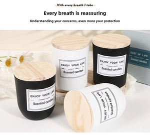 Detailed view of matte black and white scented candles with light wood lids in gift set