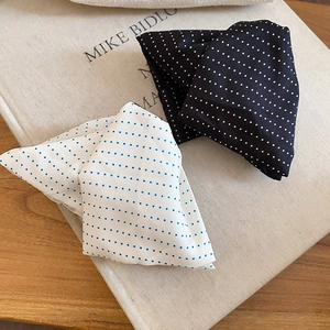 Detailed shot of triangle hair clips with classic polka dot pattern in black and white fabric