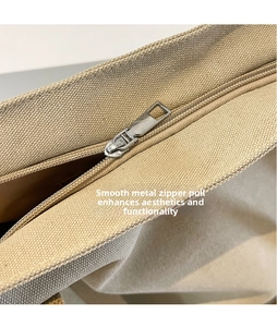 Close-up of smooth metal zipper head on durable khaki canvas tote bag detailing