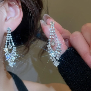 Close-up of sparkling silver tassel earrings with diamond pavé and elegant fringe