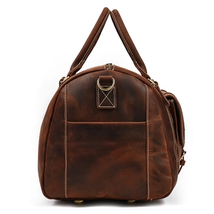 Detail view of vintage brown crazy horse leather travel bag with metal studs and side ring