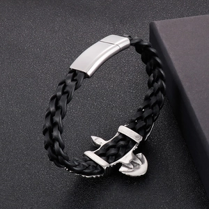 Detail of black woven leather bracelet with silver eagle wing and magnetic clasp on dark box