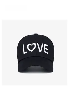 Detailed embroidery of white LOVE heart logo on a black cotton baseball sun hat