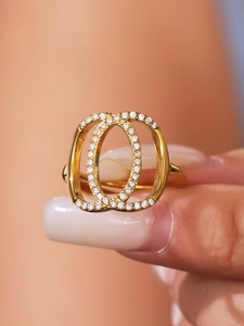 Detail macro view of double oval crossover ring with white zircon pave setting in gold finish