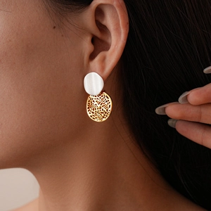 Modern 18k gold plated geometric hollow layered round earrings on female model's ear
