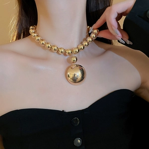 Exaggerated chunky gold beaded choker necklace with large spherical pendant for women
