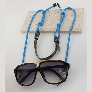 Detail of woven blue and white dopamine eyewear chain on aviator sunglasses with gold frames