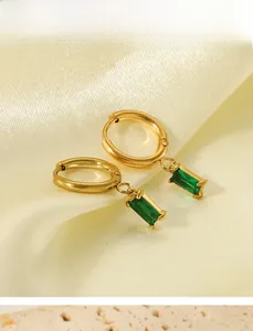 Détail de boucles d'oreilles créoles dorées 18K avec pendentifs en zircon vert émeraude