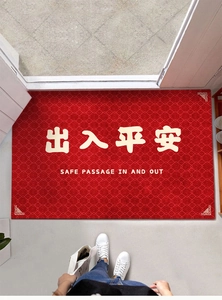 Detail of red entryway mat with Safe Passage text and traditional Greek key borders