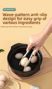 Kitchen food tongs gripping a boiled egg in a pot, made of stainless steel and silicone