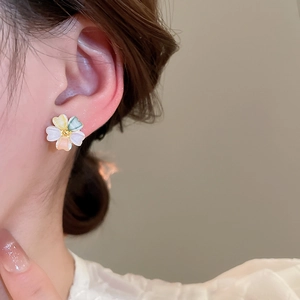 Detailed view of an 18k gold plated acrylic flower stud earring in pastel colors