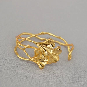 Detail der goldenen Ginkgoblatt-Manschette mit natürlicher Asttextur für Damen